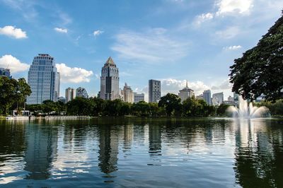 City at waterfront against cloudy sky