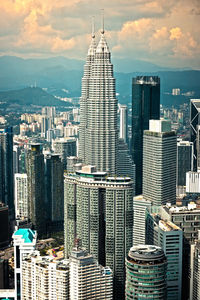 Modern buildings in city against cloudy sky