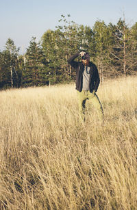 Man photographing through camera on field against sky