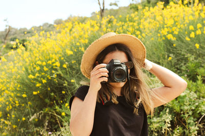 Portrait of young woman photographing camera