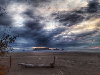 Scenic view of beach against cloudy sky