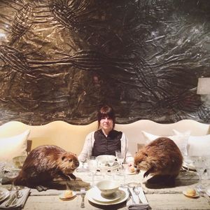 Portrait of woman with animals at dining table