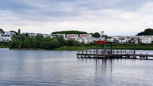 River by buildings in city against sky