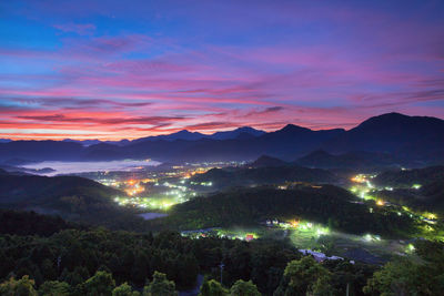 Scenic view of illuminated mountains against sky at sunset