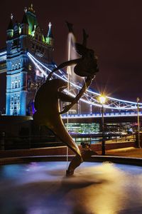 Illuminated bridge in city against sky at night