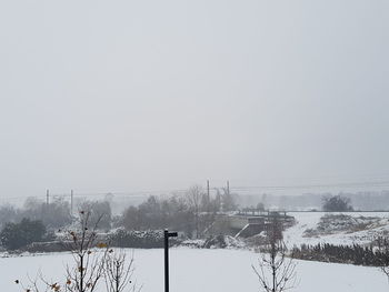 Snow covered field against clear sky