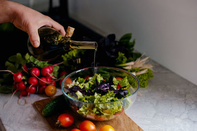 Cropped hand of person preparing food on table