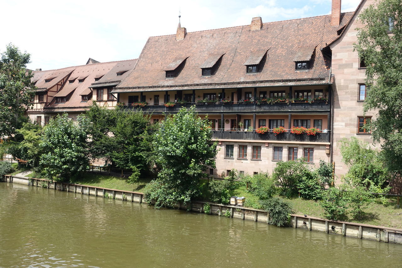 HOUSES BY RIVER AGAINST SKY