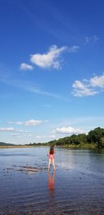 Full length of woman standing on beach against sky