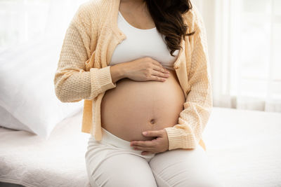 Midsection of woman touching hair