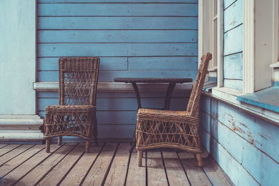 Empty chairs against blue wall of building