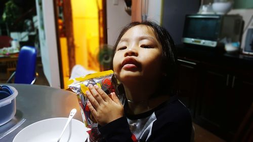 Portrait of girl holding food at home