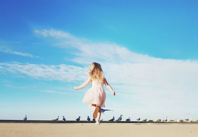 Woman on beach against blue sky