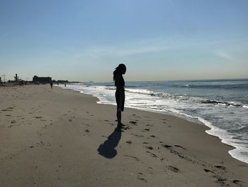 Full length of man standing on beach against sky