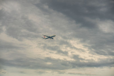 Low angle view of airplane flying against sky