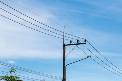 Low angle view of electricity pylon against sky
