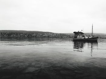 Fishing boat in sea against sky