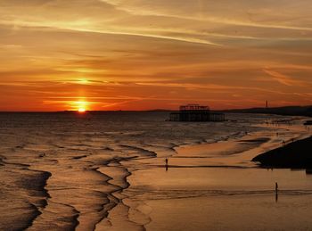 Scenic view of sea and shore against sky during sunset