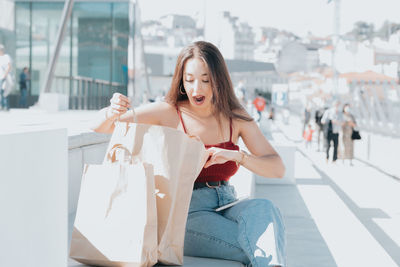 Surprised woman looking in shopping bag