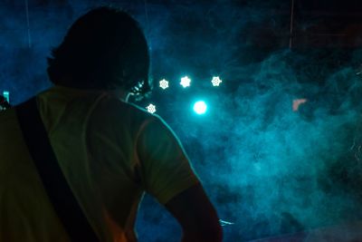 Rear view of man standing against sky at night