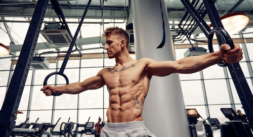 Shirtless muscular man exercising in gym