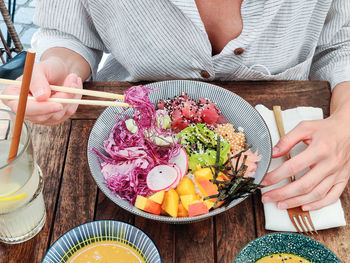 Midsection of woman having food at table