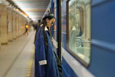 Stylish asian woman enter subway carriage. young japanese fashion model, lifestyle blogger in metro