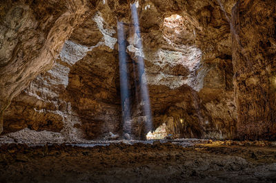 Sunlight emitting through rock formations in cave