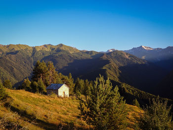 Scenic view of mountains against clear blue sky