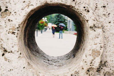 People seen through hole in wall