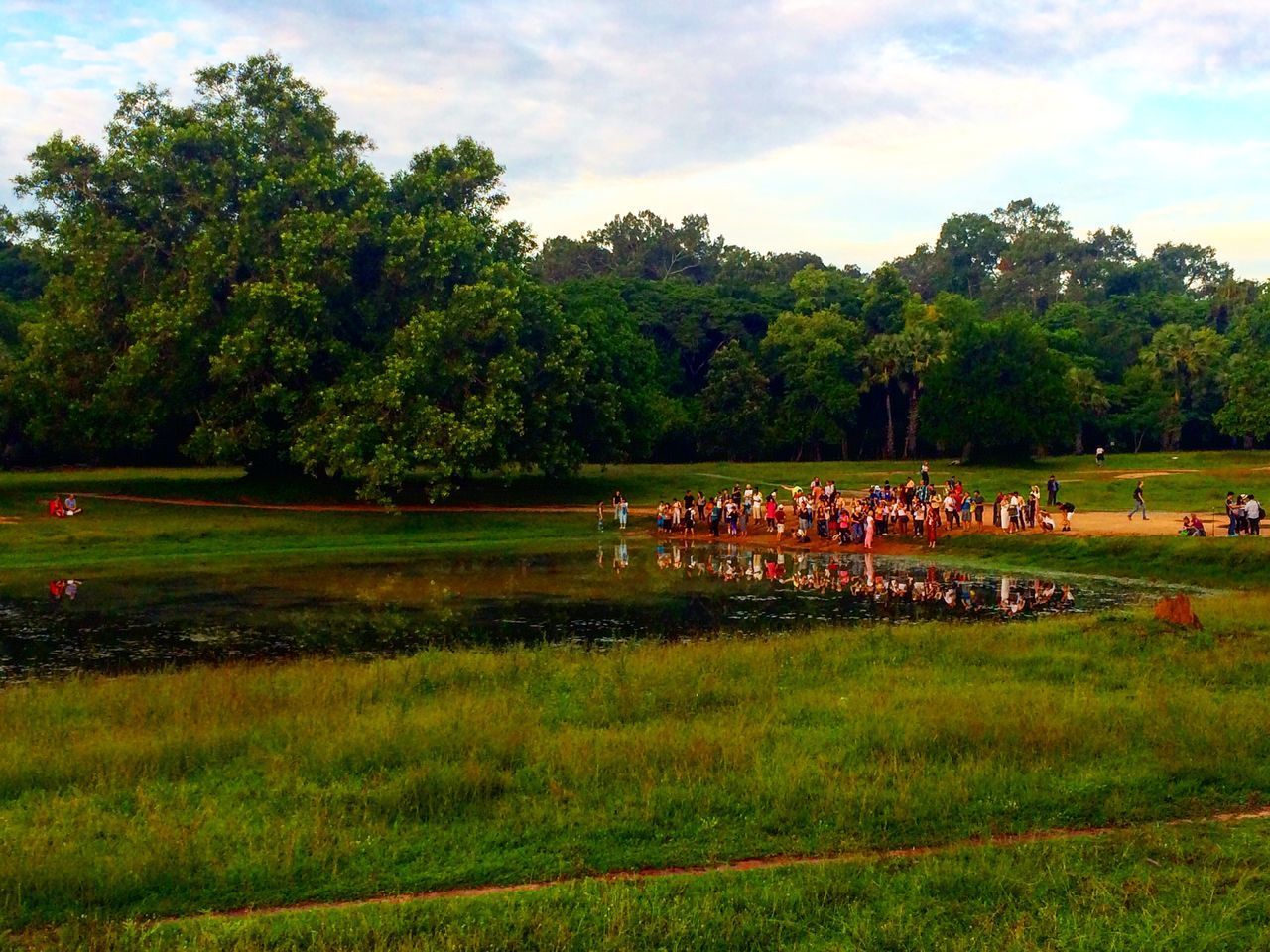 PEOPLE ON GRASSY FIELD AGAINST SKY