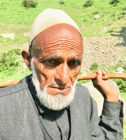 Close-up portrait of senior man wearing skull cap while standing outdoors