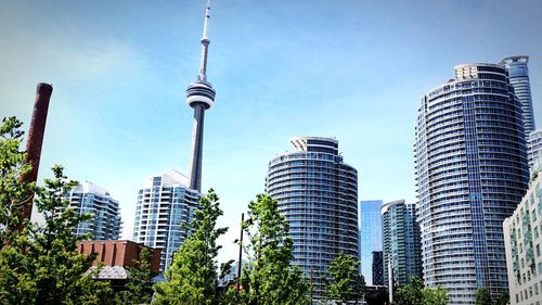 Exterior of modern buildings with cn tower against sky