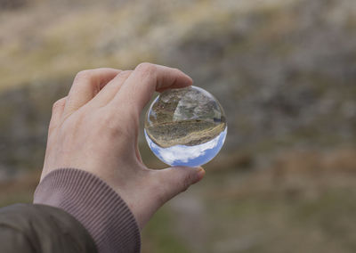 Midsection of person holding crystal ball