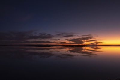 Sunset with clouds reflected on water saltworks.