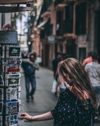 Rear view of woman standing on street