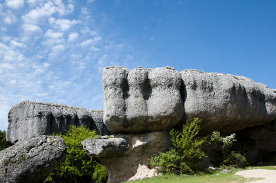 Low angle view of rocks against blue sky