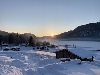 Scenic view of snow covered mountains against sky at sunset