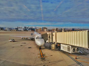 Airplane on airport runway against sky