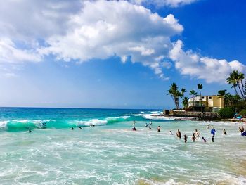 People on beach against blue sky