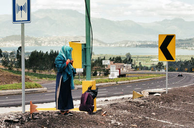 Full length of woman standing on road