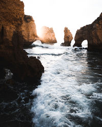 Rocks in sea against sky