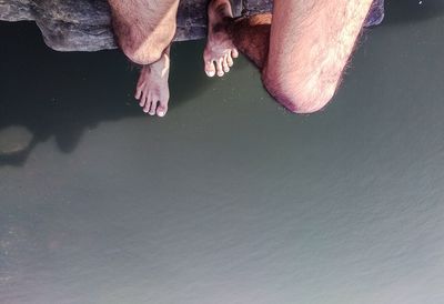 Low section of man standing in water