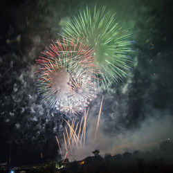 Low angle view of firework display at night