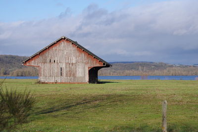 Barn on field against sky