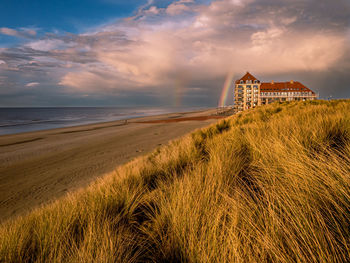 Scenic view of sea against sky with rainbow 