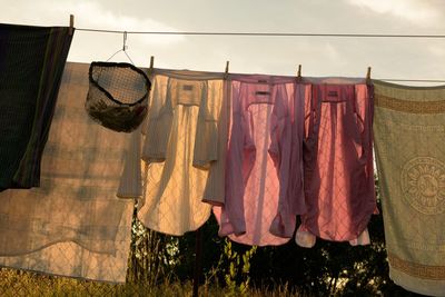 Low angle view of laundry drying on clothesline against sky