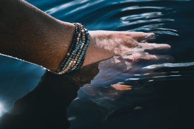 Close-up of hand by sea