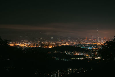 High angle view of illuminated buildings against sky at night