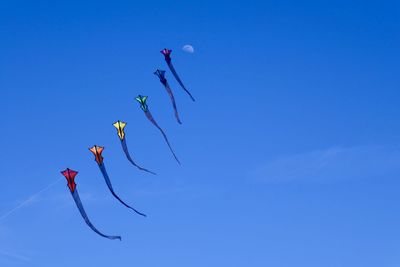 Low angle view of kite against clear blue sky